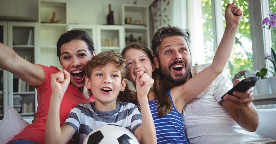 papá y mamá celebrando gol con sus hijos