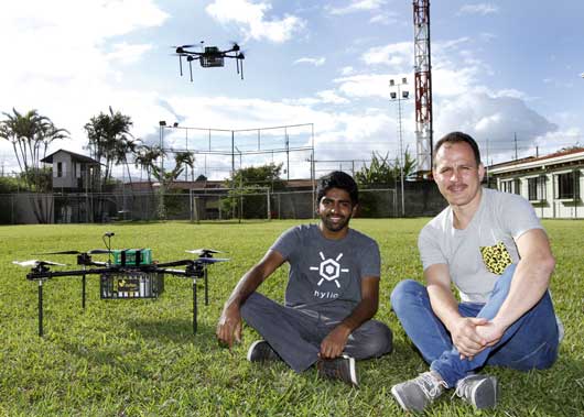 Nikhil Dixit, cofundador de Hylio, aliada de GoPato, y José Navarro, CEO de GoPato, posan en una plaza con uno de los drones que incorporará la empresa de entregas.