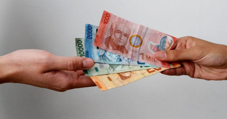 Una mano sostiene billetes de diferentes denominaciones