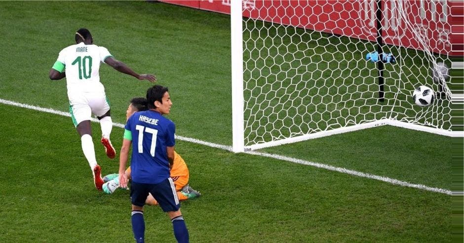 Sadio Mane celebra el primer gol de Senegal, ante la mirada de dos jugadores japoneses