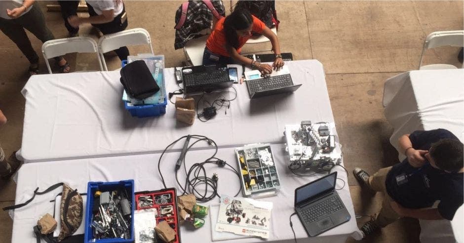 Estudiantes comparten sobre robótica en una mesa ubicada en la universidad