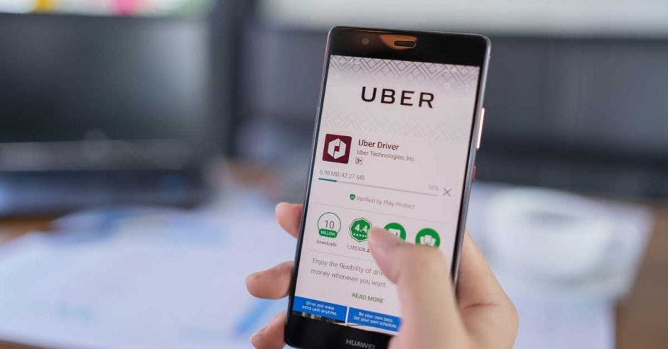 Una mujer sostiene un celular con la aplicación de Uber abierta