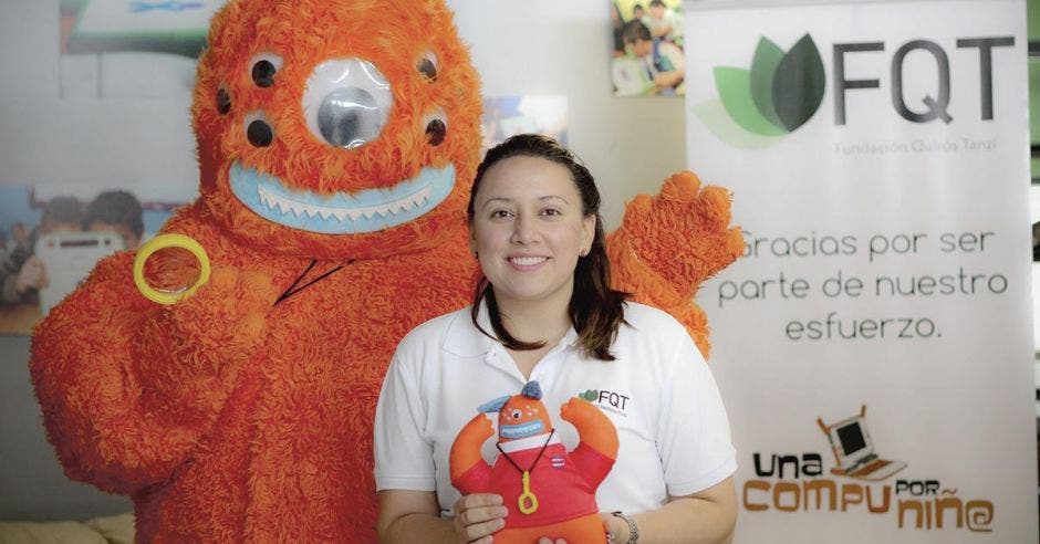 Andreina con el Browser en las manos. Browser es un peluche naranja con siete ojos, dos brazos y dos patas.