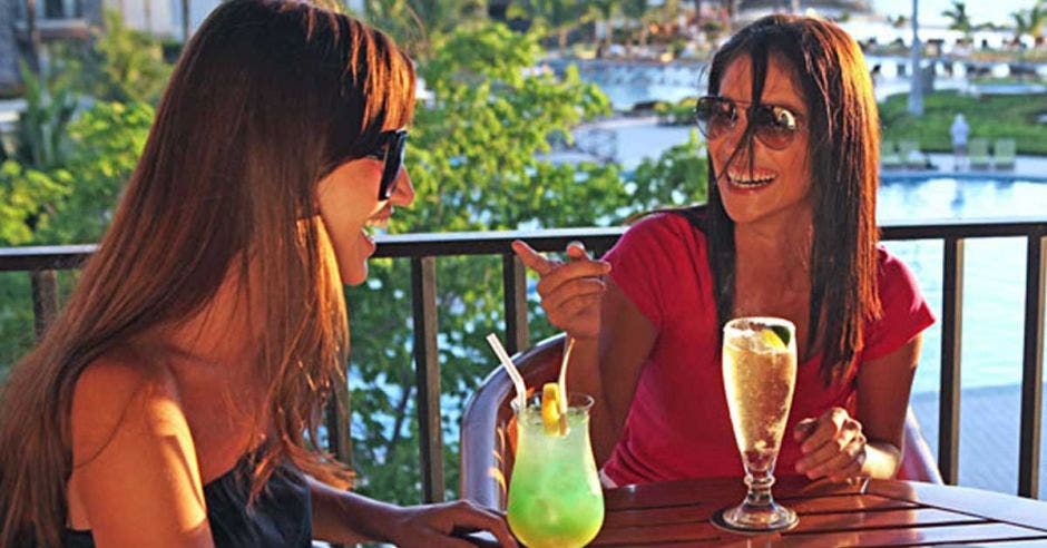 dos mujeres tomando refresco con pajilla