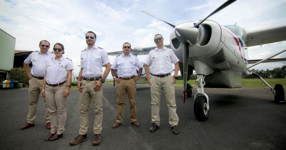 pilotos, atrás el avión