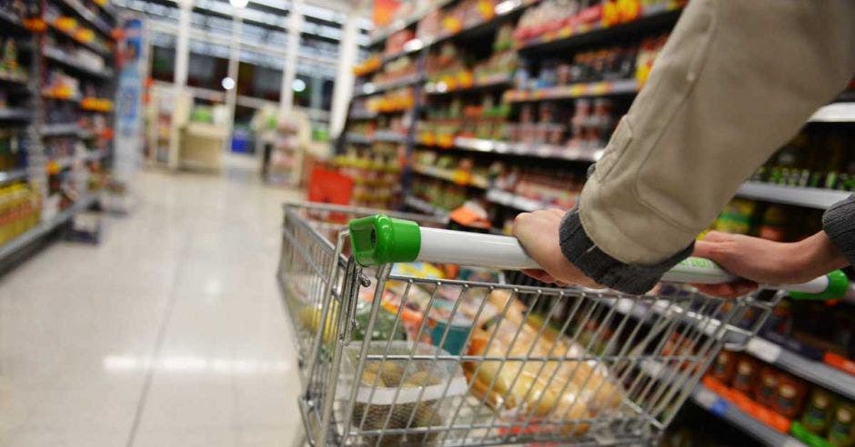 Un comprador lleva un carrito en un supermercado