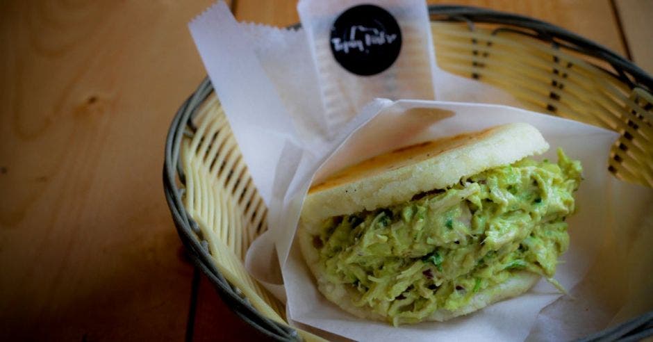 La muestra de la arepa reina pepiada en una pequeña canasta del restaurante