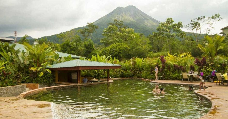 piscina con aguas termales y de fondo el Volcán Arenal
