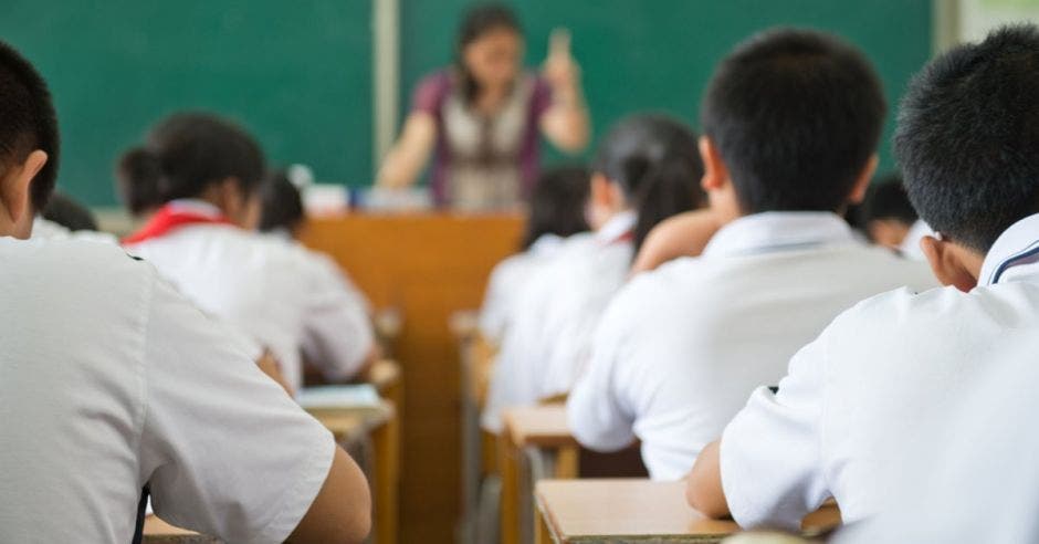 Docente y estudiantes en un aula.