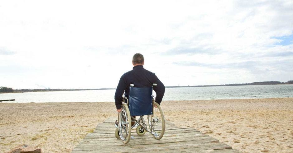 persona en silla de ruedas en la playa