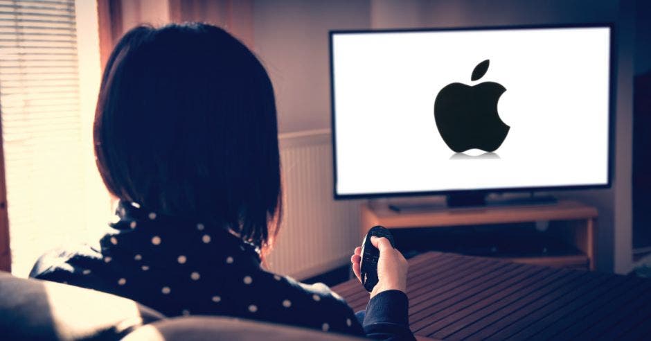 Mujer ve tv en streaming en la sala de su casa