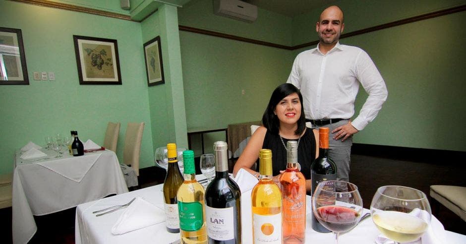 José Salom y Mariana Aguilar posan frente a una mesa con varias botellas de los productos que tratan en una mesa