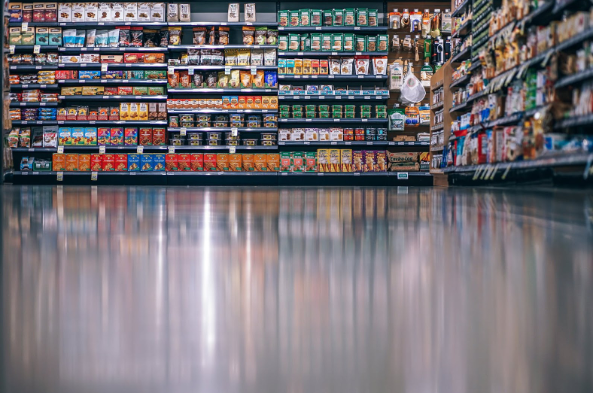 Un pasillo de un supermercado con diferentes productos de comida de fondo