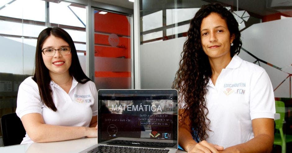 Silvia Leiva, encargada de Mercadeo de la Fundación Educando Niños y María Pia Salinas, directora general, posan con una computadora.