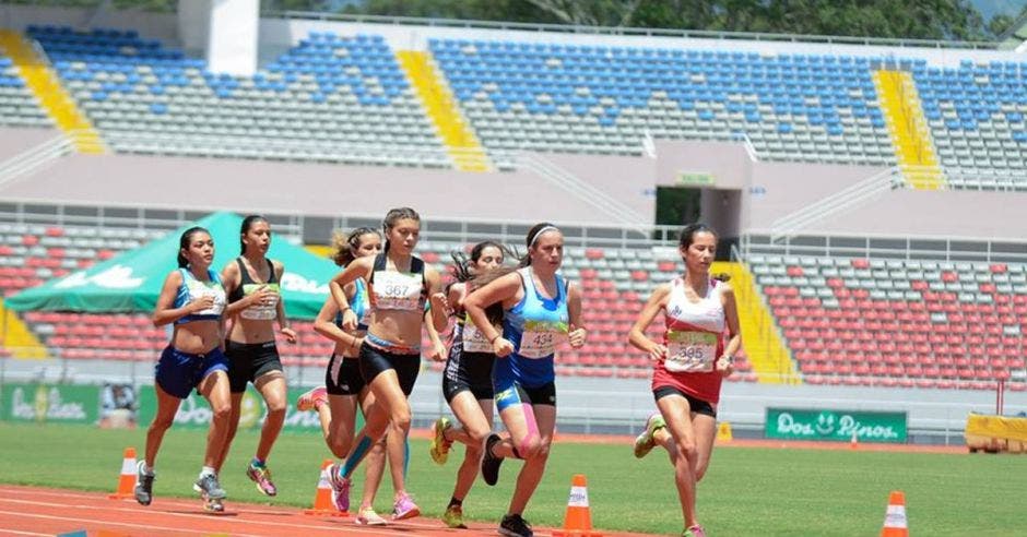 Atletas corren en una pista