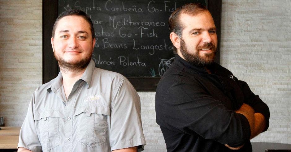 Los dueños del local uno de camisa gris y el otro de camisa negra