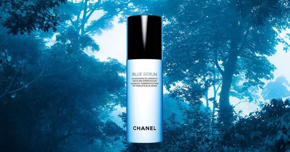 Imagen de la botella de Blue Serum de Chanel sobre el fondo de un bosque