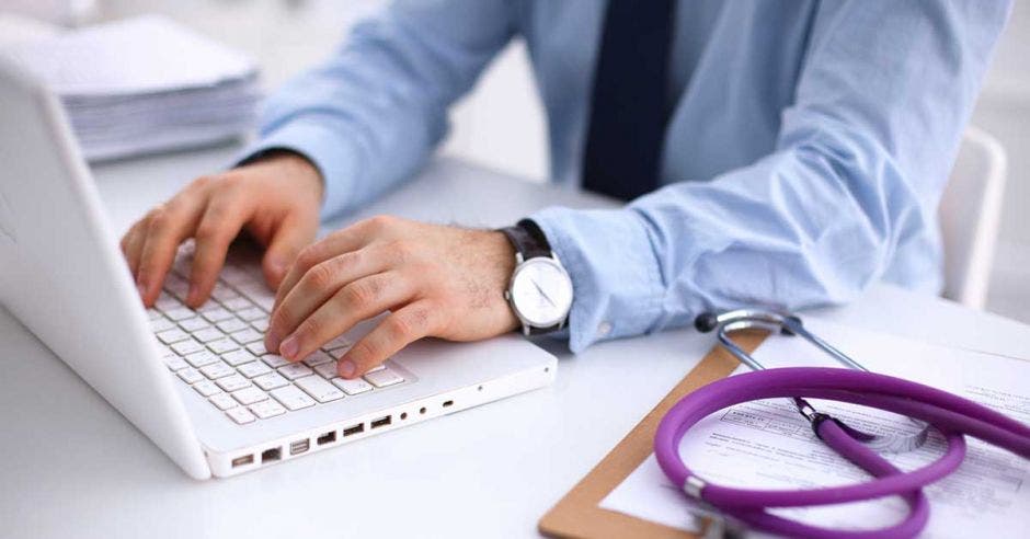 Un doctor revisa expedientes en su computadora