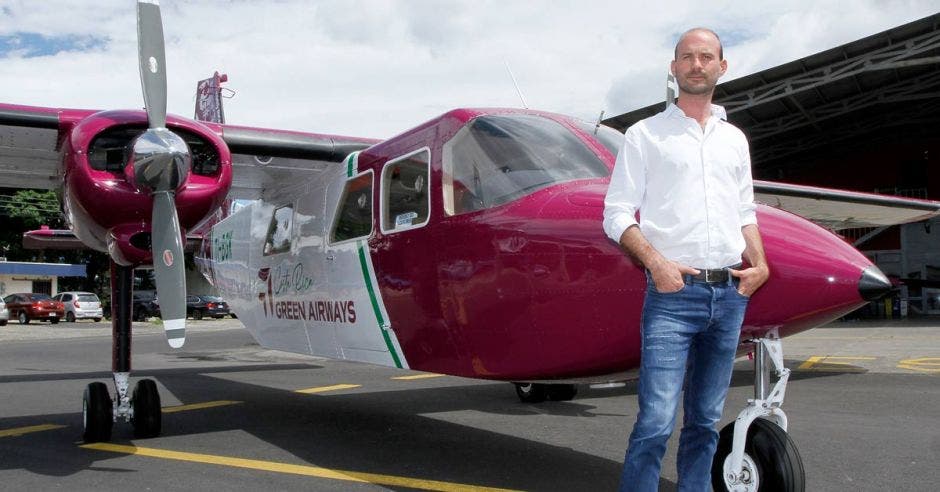 Everardo Carmona, con el avión de la aerolínea de fondo