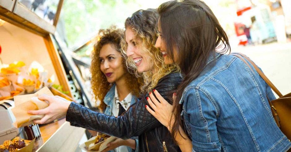 mujeres comprando comida en un food trucks