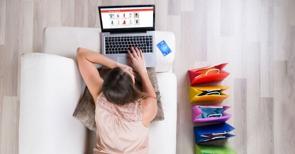 Una mujer ve en su computadora las compras que podría realizar,