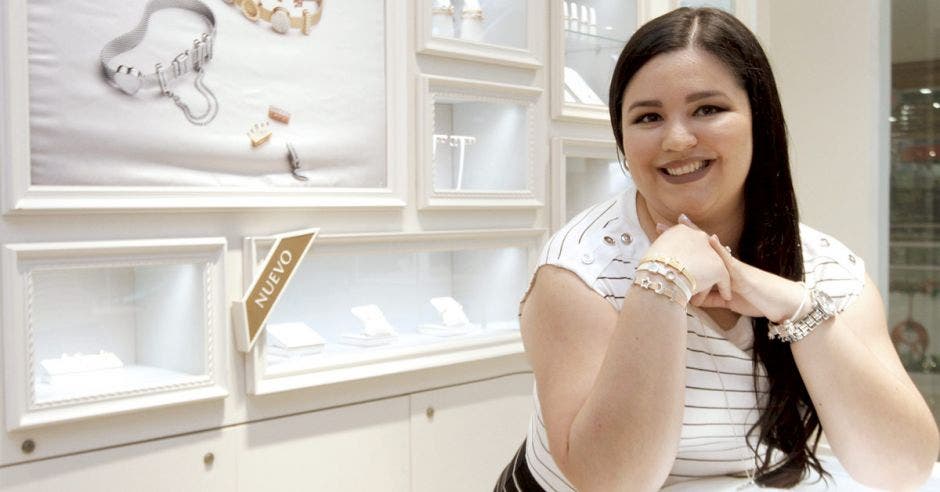 La gerente de pelo negro, vestida de blanco, exhibiendo las pulseras