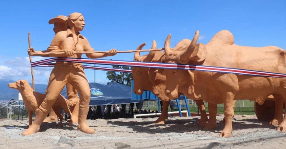 Escultura de un boyero, una boyera y su zaguate, junto a dos bueyes que halan la carreta.