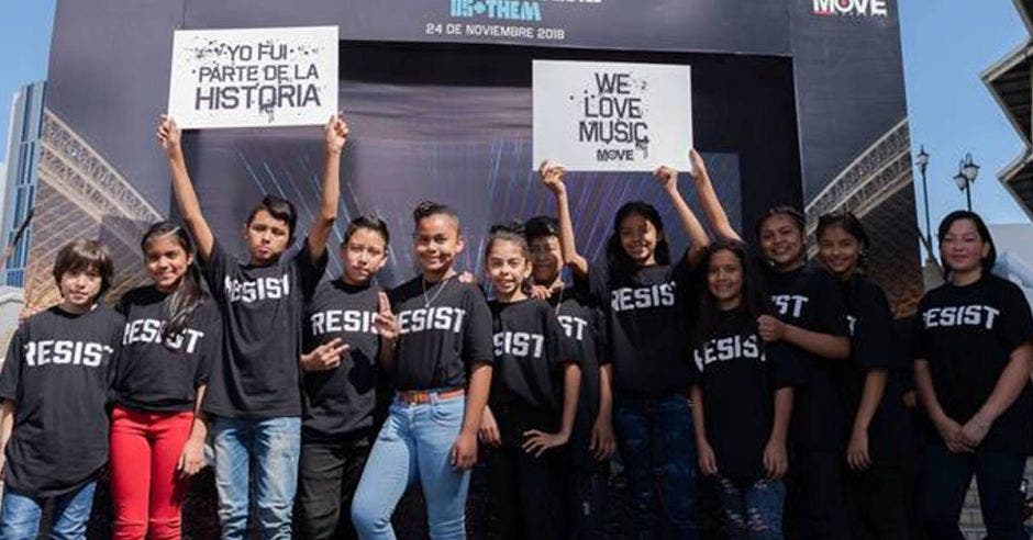 un grupo de niños con camisas negras que dicen "resist"