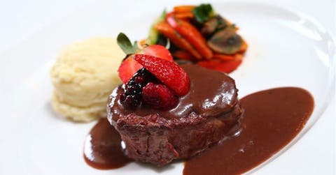 Lomo de rez en salsa de frutos rojos, con unas fresas y un pure a lado