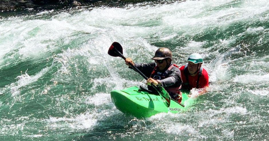 Una kayakero de seguridad siendo entrenado en los rápidos de un río.