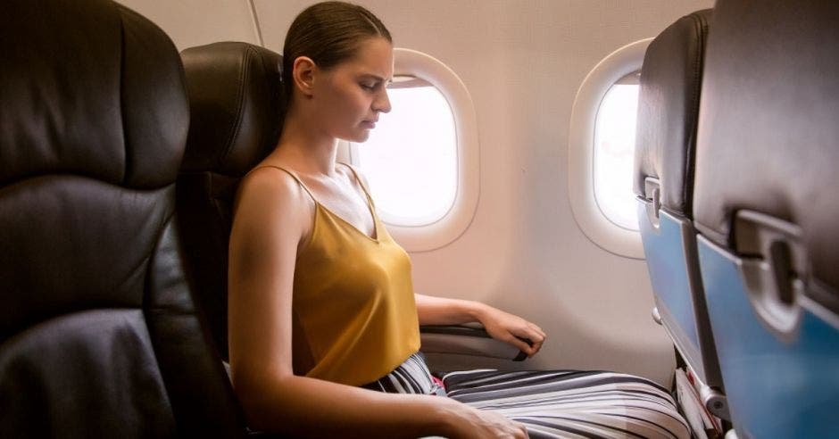 mujer sentada en un asiento de avión