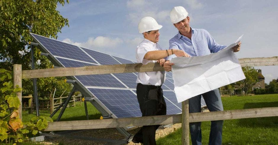 Un par de trabajadores instalan un panel solar