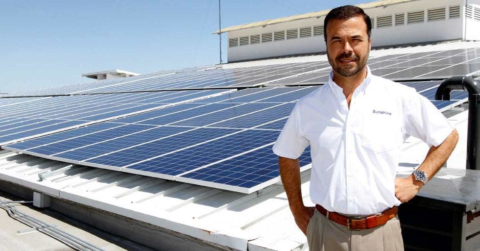 Eduardo Kopper posa en un techo con paneles solares instalados