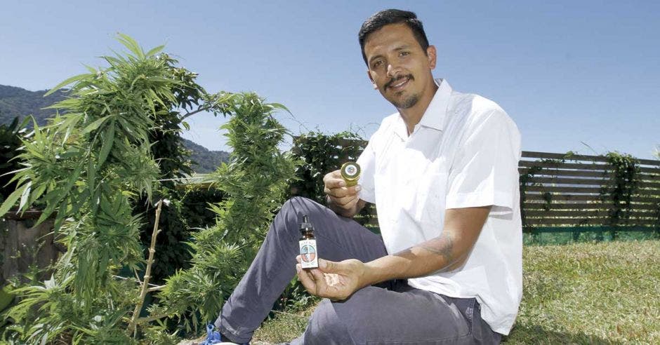 Juan Zuniga posa junto a una planta de marihuana