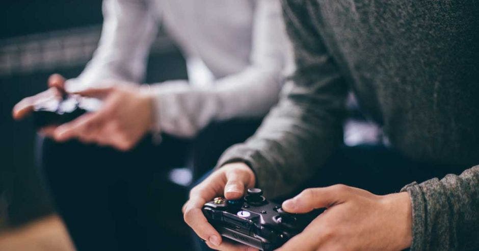 Alguien juega con un xbox frente a un televisor