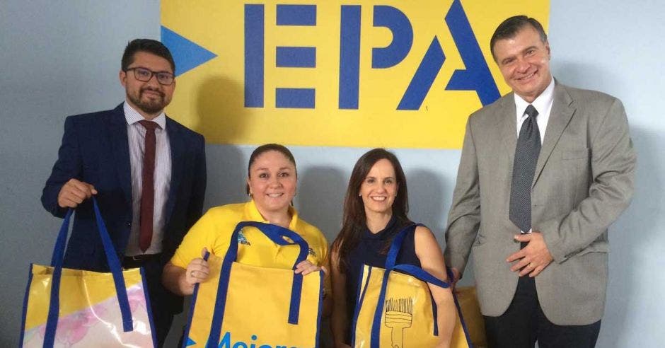 Cuatro personas frente al logo de EPA sostienen bolsas amarillas