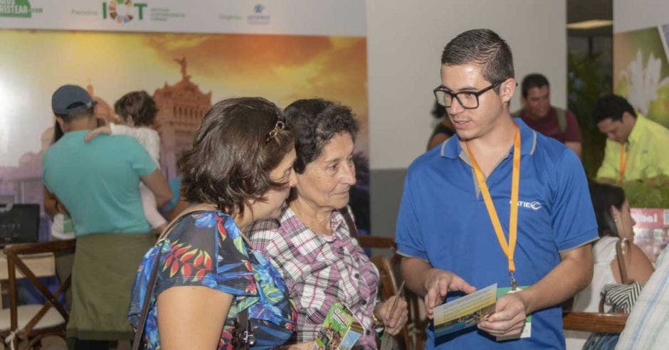 muchacho hablando con dos señoras en Expotur edición 2017