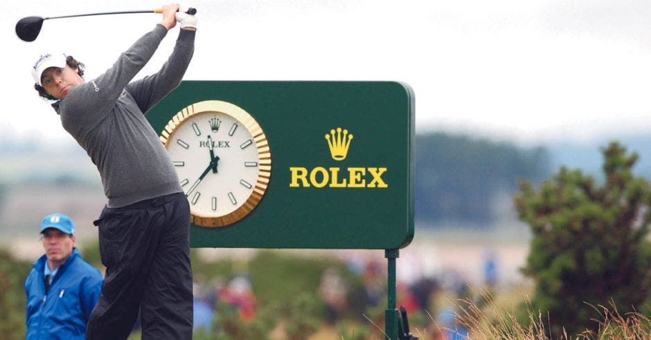 Golfista jugando en campo de golf con un rótulo marca Rolex
