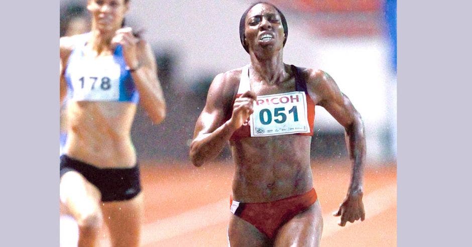Mujer compitiendo en una carrera de 400 metros vallas