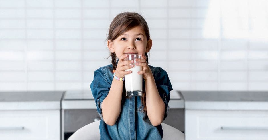 niña con un vaso de leche en las manos