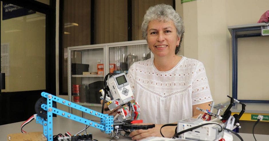 Mujer sosteniendo un robot.