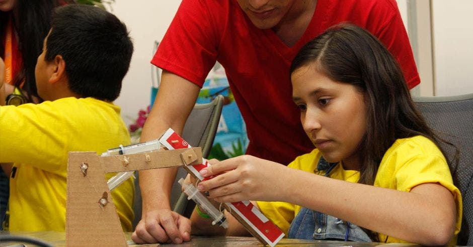 niña fabricando un brazo a partir de cartón