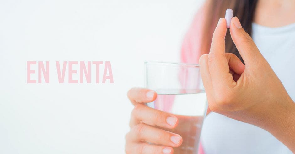 Una mujer tomando una pastilla con la palabra en venta