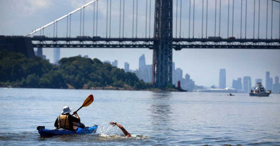 Persona nadando junto a kayak en manhattan