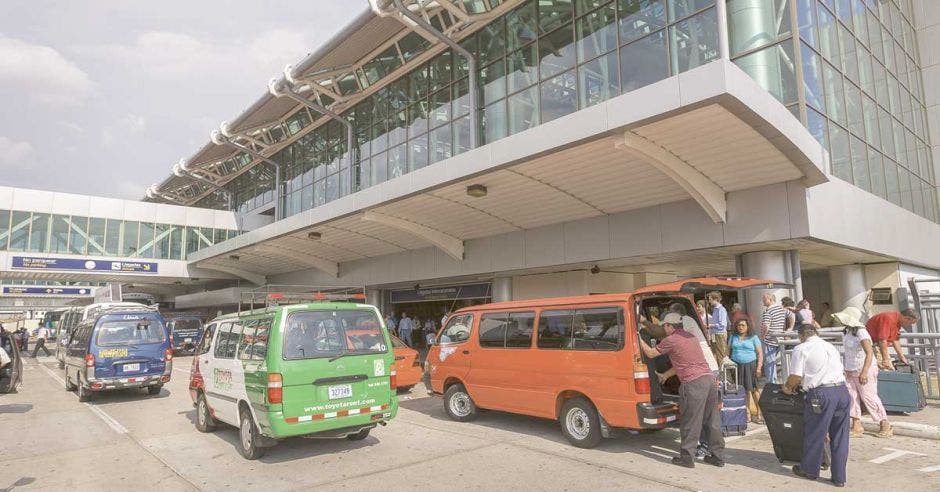 taxista del aeropuerto bajando maletas del carro