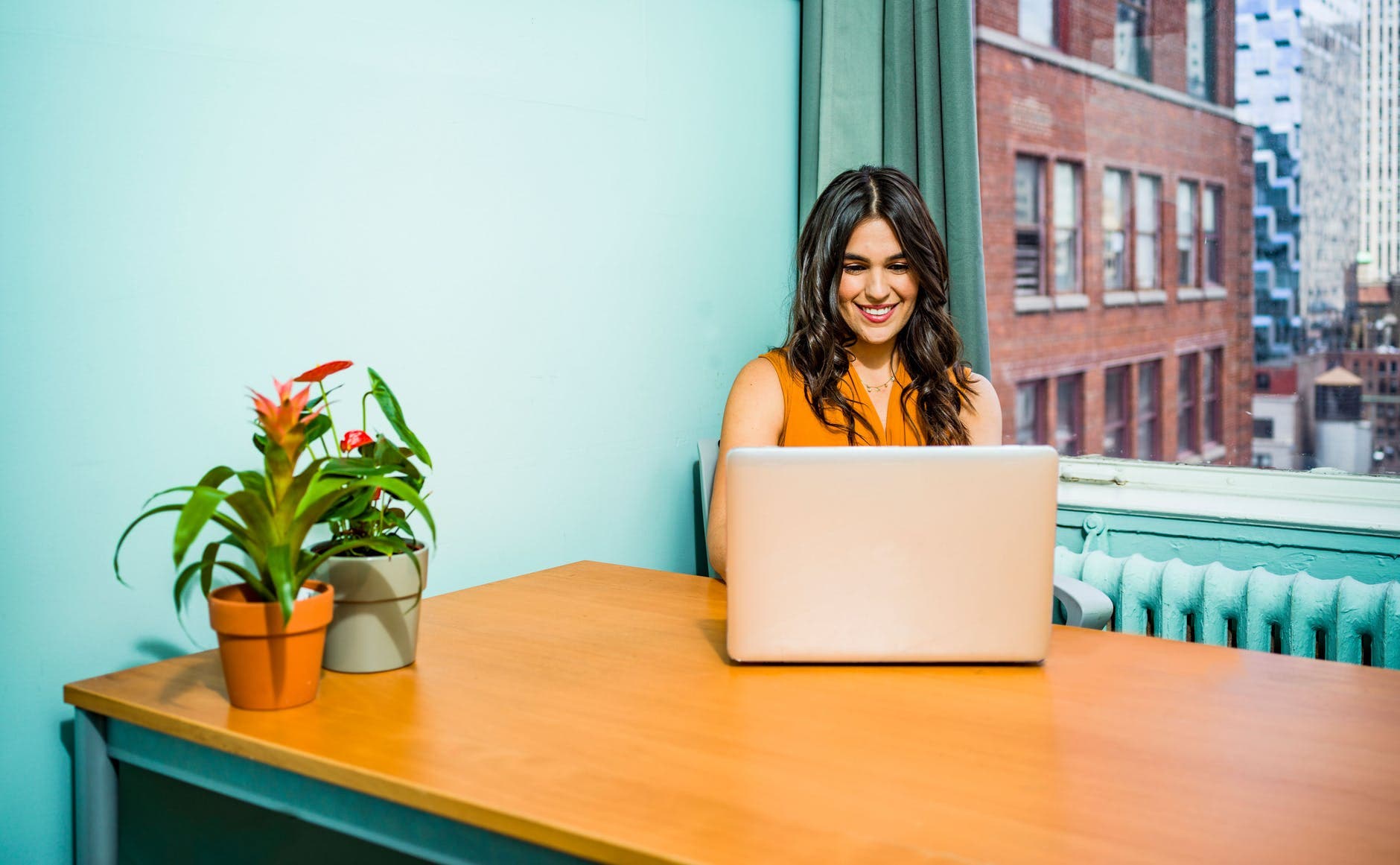 Mujer sonriendo frente a una laptop