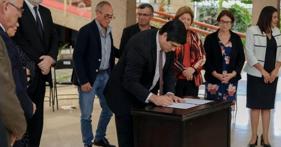 El Presidente, acompañado de varios ministros, durante la firma del decreto.