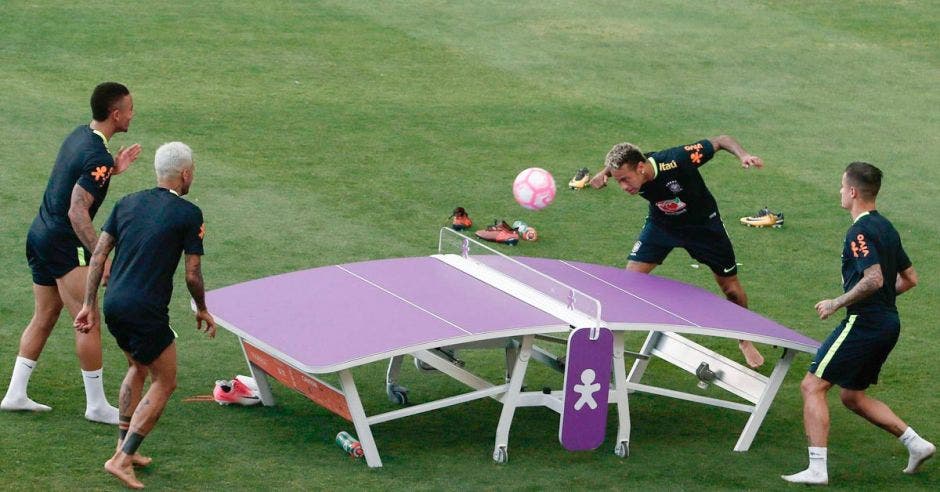 jugadores alrededor de una mesa jugando fútbol