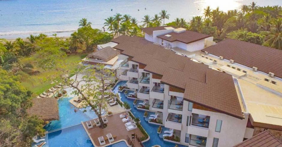 vista área del edificio de habitaciones, piscina y playa