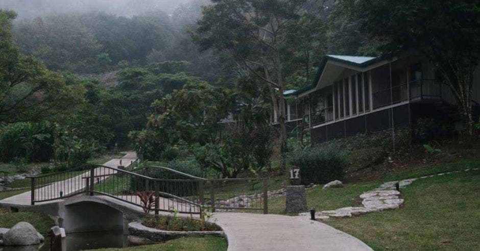 sendero, al fondo cabañas en medio del bosque